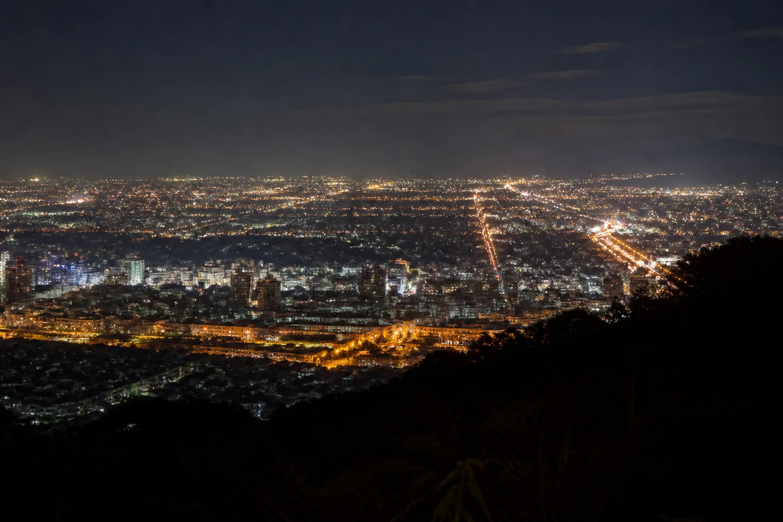 オレンジの街灯と白いビルの明かりが混ざる街の夜景。光源ごとに色が違う夜景写真の例